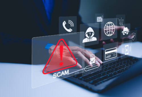Scam Alert Warning with Cybersecurity Icons. A person using laptop, warning sign for scams with icons representing online threats, phishing, and cybersecurity. Unknown person, suspicious scammer,